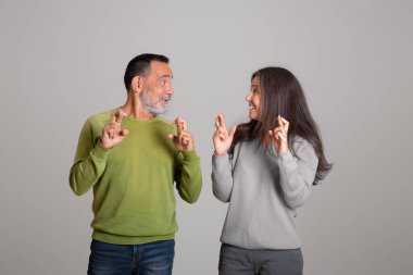 Olumlu Kafkasyalı yaşlı karı ve koca zafer hayalleri kurar, bir dilek tutarlar, gri arka planda, stüdyoda izole olurlar. İnsanların duyguları ve yaşam tarzı, inanç ve umut, başarı, reklam, teklif