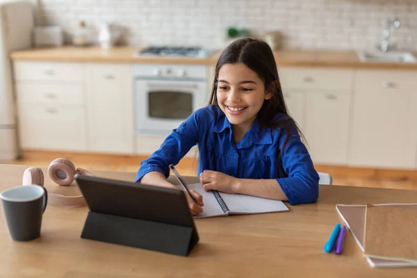 电子学习 快乐的中东女学生使用数码记事板和记笔记在家拥抱在线教育 在远程学习中做在线作业的小女孩 — 图库照片