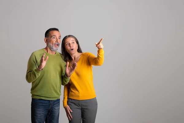 Positiv Schockiertes Kaukasisches Ehepaar Zeigt Mit Dem Finger Auf Kopierraum — Stockfoto