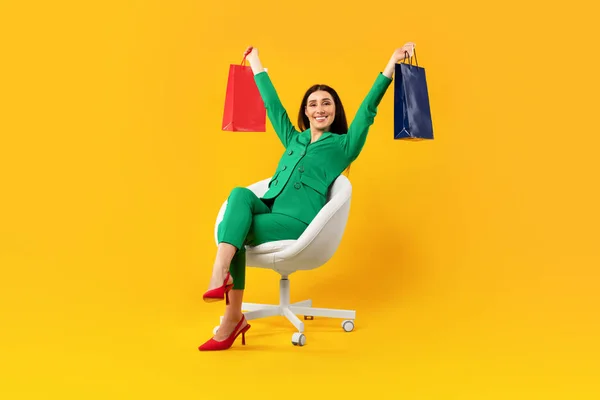 Heyecanlı Kadın Alıcı Sandalyede Oturuyor Renkli Alışveriş Torbalarıyla Kaldırıyor Sarı — Stok fotoğraf