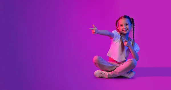 Positive Happy Smiling Cute Kid Preteen Girl Sitting Floor Pointing — Stock Photo, Image