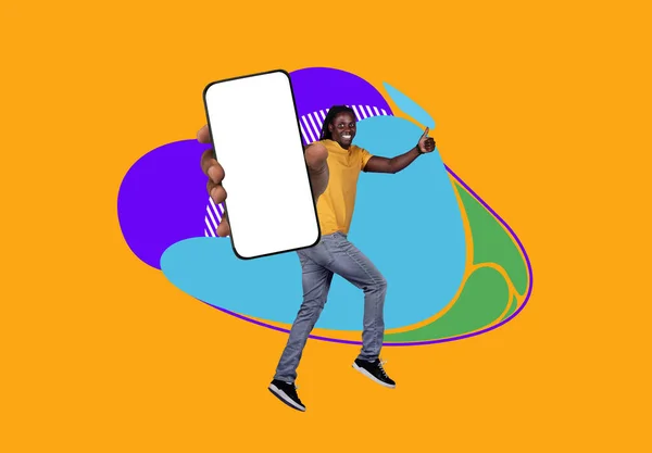 モバイル広告 陽気な黒の男性ジャンプと白い画面で空白のスマートフォンを表示 カメラで幸せなアフリカの男ジェスチャー親指アップ カラフルな抽象的な背景上の楽しみを持っています コラージュ モックアップ — ストック写真