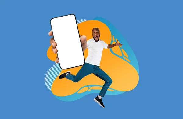 カラフルな抽象的な背景の上にジャンプしながら 空のスマートフォンの画面を示す興奮した黒人男性 幸せなアフリカ系アメリカ人男性推薦新しいモバイルアプリやウェブサイト コラージュ モックアップ — ストック写真