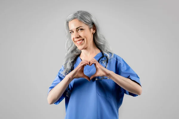 Профессионал Здравоохранения Счастливая Женщина Доктор Показывает Сердечный Жест Руками Позируя — стоковое фото