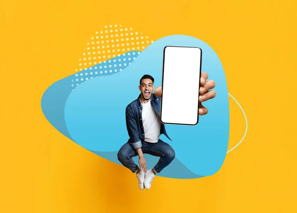 カラフルな背景 幸せな若い中東の男は新しいアプリやウェブサイト クリエイティブコラージュ モックアップ広告を手に大きな空白のスマートフォンでジャンプ陽気なアラブの男 — ストック写真