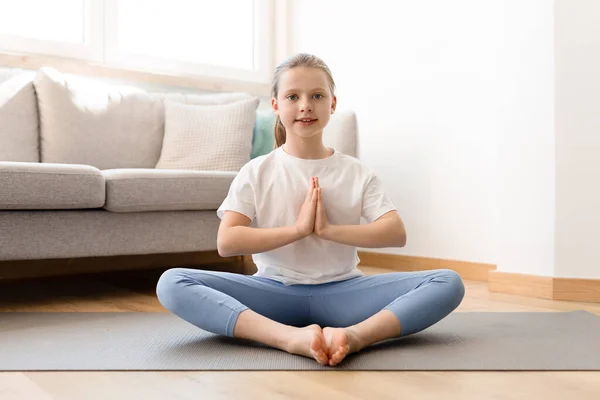 穿着运动服微笑的高加索中年女孩练习瑜伽 在客厅的垫子上冥想 体育与和平 — 图库照片