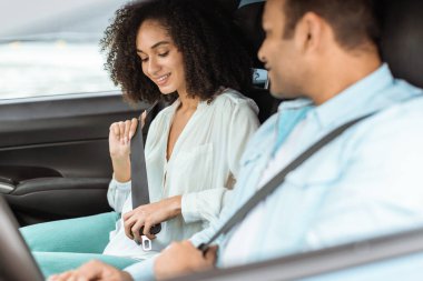 Yol güvenliği. Araç yolculuğuna hazırlanan emniyet kemeri takan Arap çift, yeni alınmış otomobilde oturarak güvenli sürüş alışkanlıkları geliştiriyor. Otomobil sigortası konsepti. Seçici odak