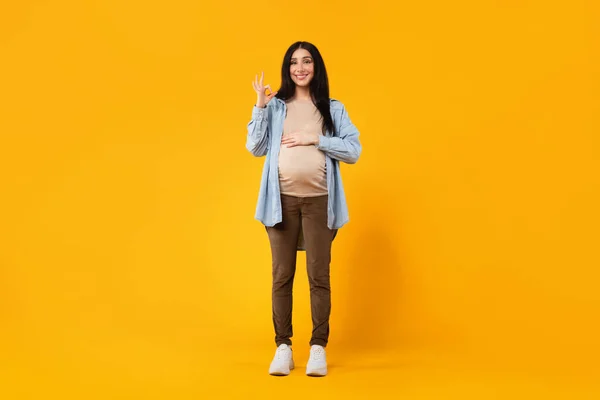 Serene Pregnancy Moment Young Pregnant Woman Gesturing Okay Touching Belly — Stock Photo, Image