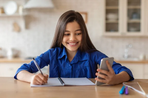 Online Education Preteen Girl Doing Schoolwork Smartphone Taking Notes Sitting — Stock Photo, Image