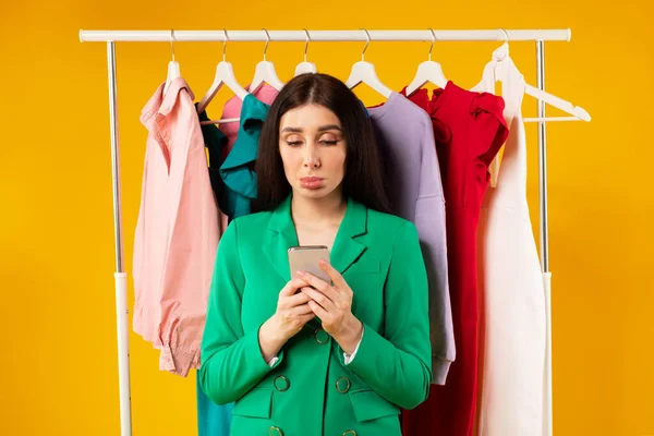 Giyim Mağazasının Yanında Renkli Kıyafetlerle Dikilen Cep Telefonu Kullanan Şık — Stok fotoğraf