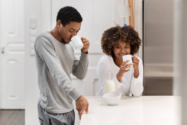 Binlerce yıllık güzel Afro-Amerikan çifti mutfak masasında pijama giyer, fincanları tutar, sabah kahvelerinin tadını çıkarır, sohbet eder, fotokopi çekerler.