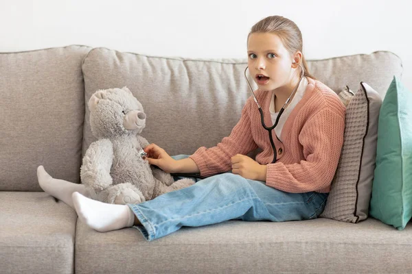 Shocked Funny Caucasian Little Girl Playing Doctor Toy Bear Listens — Stock Photo, Image