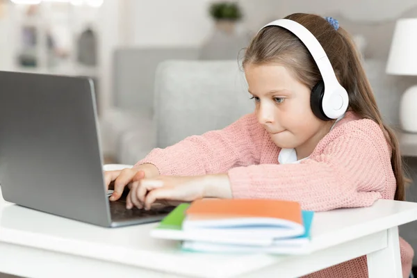 Beschäftigt Konzentriert Kaukasische Kleine Mädchen Kopfhörer Typen Hausaufgaben Machen Sieht — Stockfoto