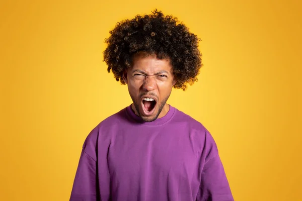黄色の背景 スタジオに隔離されたオープン口で叫んで紫色のTシャツの悲しい怒り成熟した黒い巻き男 ストレス 人間の感情 — ストック写真