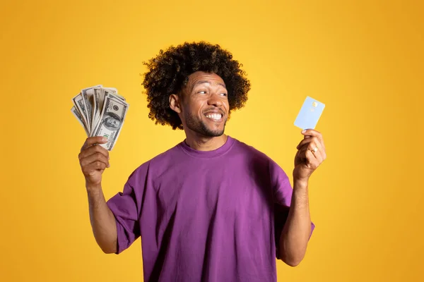 보라색 티셔츠를 곱슬머리 남자가 카드를 노란색 스튜디오에서 고립된 모습을 리모컨 — 스톡 사진