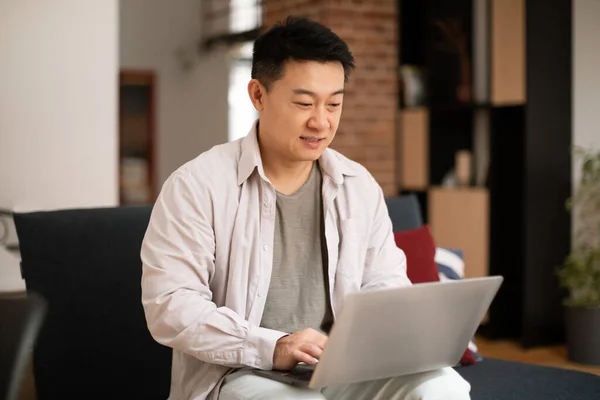 프리랜서 아시아의 사업가가 소파에 앉아서 집에서 일하고 노트북을 사용하고 컴퓨터 — 스톡 사진
