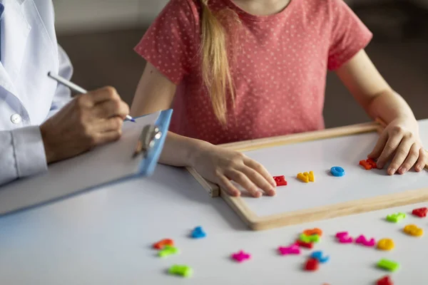 Nierozpoznawalna Dziewczynka Ćwicząca Tablicą Alfabetu Podczas Sesji Specjalistką Rozwoju Dziecka — Zdjęcie stockowe