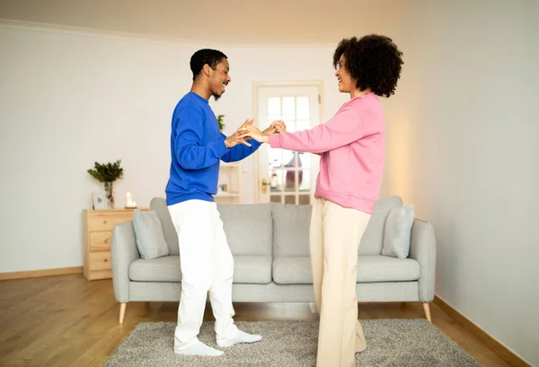 趣味を踊る アフリカ系アメリカ人の若者を愛する配偶者は 自宅のモダンなリビングルームでダンスセッションを楽しみ 週末に一緒に楽しみ カジュアル服を着ています 幸せな結婚の瞬間コンセプト — ストック写真