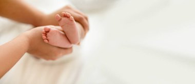 Siyah milenyum anneleri küçük bebek ayaklarını beyaz yatakta tutarlar, rahatlığın, sevginin ve yatak odasında boş zamanın tadını çıkarırlar. Çocuk bakımı tatili, ebeveynlik, sağlık hizmetleri ve evde aile, reklam ve sunum