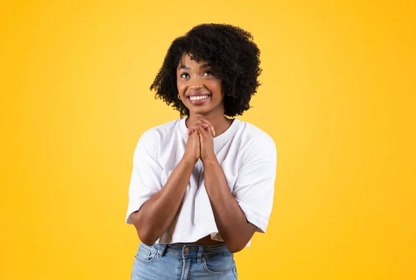 快乐的年轻非洲裔美国卷曲女人用手做祷告手势 在黄色的工作室背景下与世隔绝 希望与信仰 感激与爱 — 图库照片
