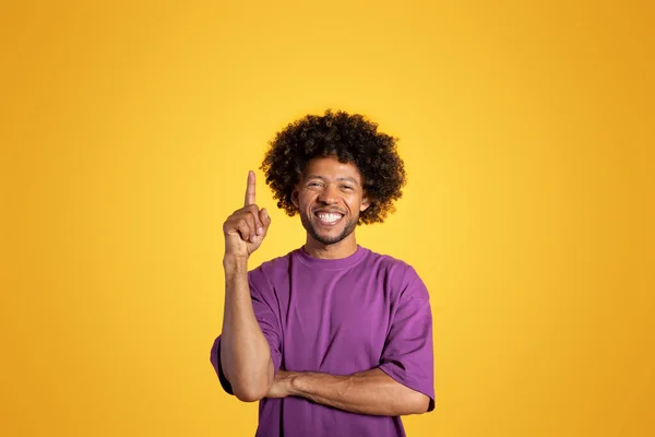 快乐成熟的黑色卷曲男子在紫色T恤显示手指向上 得到的想法 孤立在黄色背景 工作室 创建解决方案 头脑风暴 广告和提供 推荐销售 — 图库照片