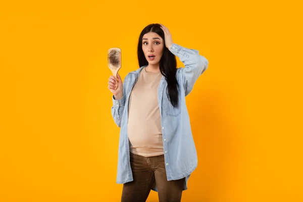 妊娠の変化 若い期待の母親は 黄色の背景に立って ホルモンバランスによって引き起こされる問題を抱えて 脱毛に取り組んでいます — ストック写真