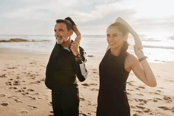快乐成熟的欧洲男人和女人一起做手臂运动 伸展身体 一起在海滩上锻炼 户外运动 晨练和体格保健 — 图库照片