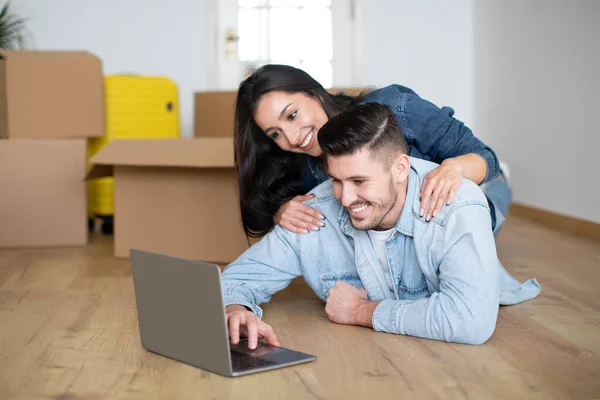 Szczęśliwa Para Europejczyków Korzystająca Laptopa Leżącego Podłodze Nowym Mieszkaniu Wśród — Zdjęcie stockowe