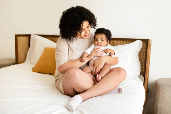 Neşeli Siyah Milenyum Annesi Küçük Bebeğini Beyaz Yatakta Kucağına Aldı — Stok fotoğraf