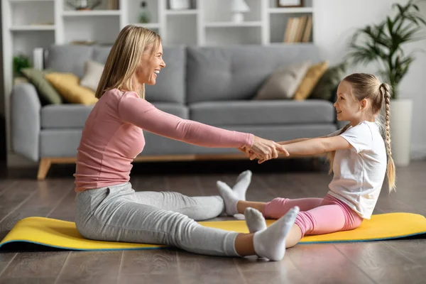 Sport Activities. Happy Family Mother And Little Daughter Exercising Together At Home, Cheerful Woman And Her Cute Female Child Doing Fitness Workout In Living Room Interior, Holding Arms And Smiling