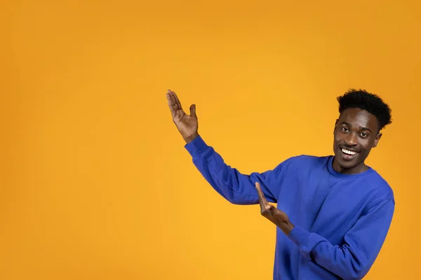 黄色のスタジオの背景にテキストや広告のためのコピースペースを示すスタイリッシュな衣装で幸せな笑顔千年黒人男性 アフリカ系アメリカ人の男お勧め素敵なオファーや契約 — ストック写真