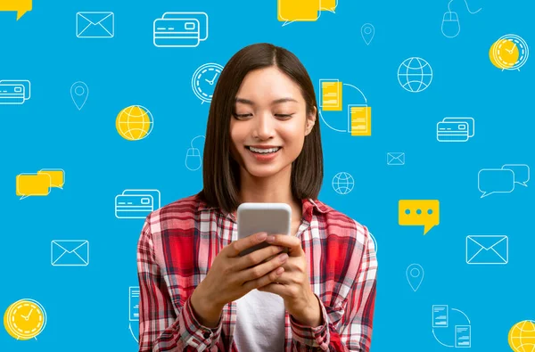 微笑着年轻的亚洲女人 手里拿着手机 在蓝色背景的不同数码世界的图标上摆出姿势 现代技术 资金转移 银行业务 网上支付概念 移动应用 — 图库照片