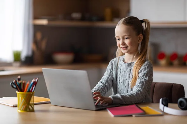 在家里用笔记本电脑学习 在电脑键盘上打字 在网上微笑 享受家庭学习和远程学习 复制空间 这些都是非常有趣的小女生学习 — 图库照片