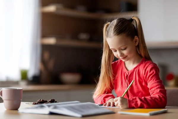 Niedliches Kleines Mädchen Das Notizblock Schreibt Während Hause Schreibtisch Sitzt — Stockfoto