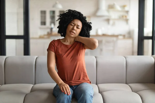 Tired Black Woman Suffering Neck Pain While Sitting Couch Home — Stock Photo, Image