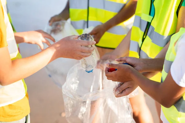 身穿制服的国际青少年把垃圾和塑料瓶装进袋子里 在海滩上回收 环境保护 清洁地球 保护海洋 — 图库照片