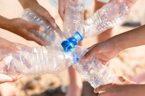 不同的青少年和年轻人手拿着垃圾 把塑料瓶放在海滩上 修剪好 环境保护 清洁地球 回收利用 保护海洋 生态拯救 — 图库照片