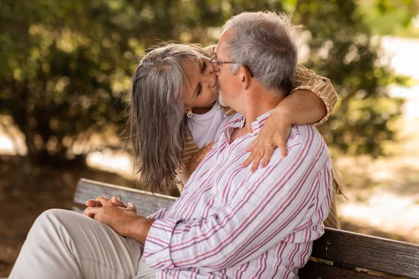 Pozitivní Starší Kavkazská Manželka Objímá Líbá Manžela Sedí Lavičce Parku — Stock fotografie
