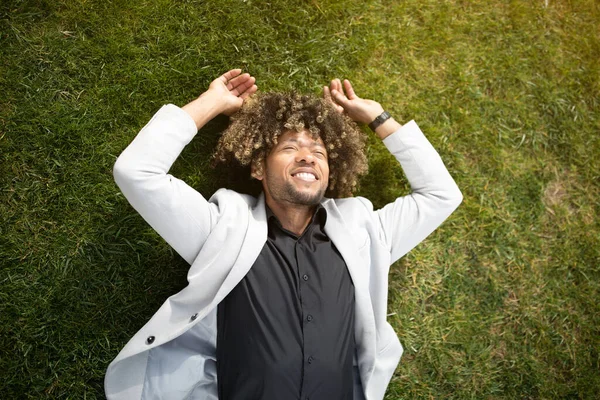 Расслабленный Афроамериканец Предприниматель Лежит Зеленой Траве Газоне Отдыхает Время Перерыва — стоковое фото