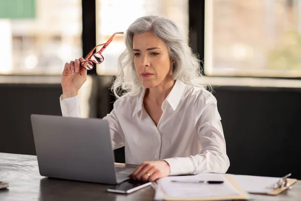 Serious Professional Businesswoman Looking Laptop Working Online Thinking Holding Brille — Stockfoto