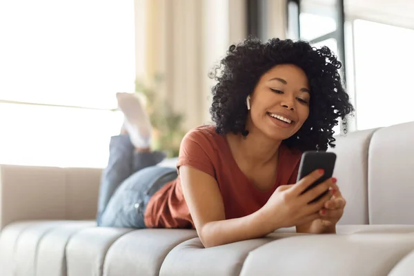 Kablosuz Kulaklıklı Gülümseyen Siyah Kadın Portresi Evde Akıllı Telefonuyla Dinlenen — Stok fotoğraf