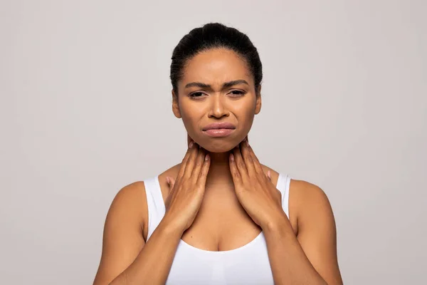 不快乐的年轻黑人女人摸着她的脖子 喉部疼痛 检查在灰色工作室背景下孤立的大腺样体 复制空间 扁桃体炎的概念 — 图库照片