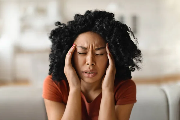偏頭痛の概念 自宅でリラックスしながら急性頭痛を患っている若いアフリカ系アメリカ人女性のマッサージ寺院 手で頭に触れるストレスの多い黒人女性のクローズアップショットフリースペース — ストック写真