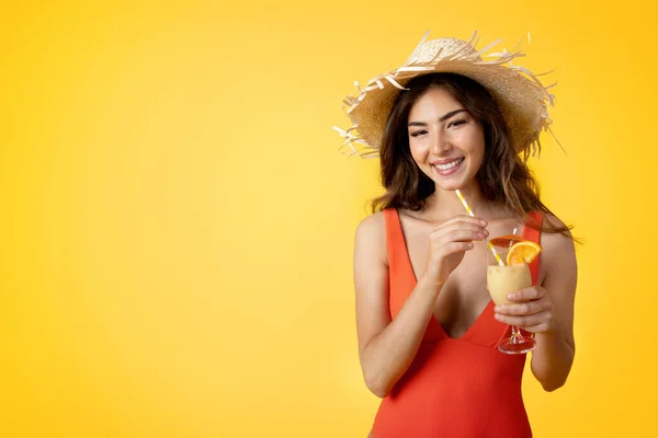 水着と熱帯カクテルと帽子の陽気なミレニアルミックスレースの女性は黄色のスタジオの背景に隔離された休暇をお楽しみください 夏の休暇旅行 自由時間 広告やオファー — ストック写真