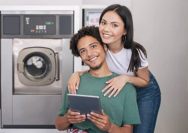 Laundry Service Happy Young Diverse Couple Posing Digital Tablet Hugging — Stock Photo, Image