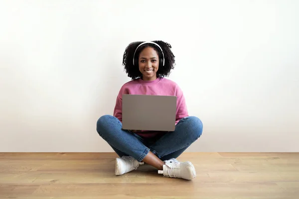 Smiling Millennial African Curly Woman Typing Laptop Floor Living Room — стоковое фото