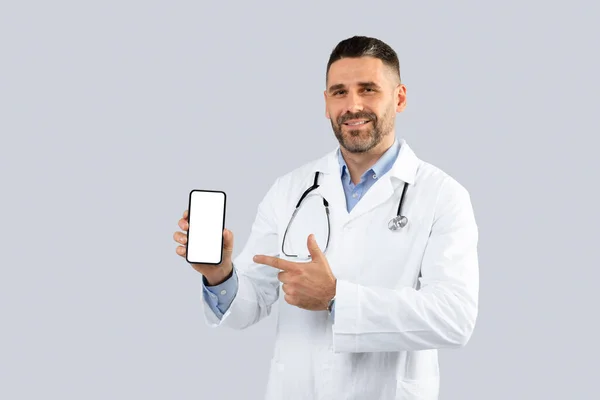 Neşeli Orta Yaşlı Doktor Elindeki Boş Ekranı Işaret Ediyor Hekim — Stok fotoğraf
