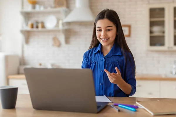 デジタル ラーニング バーチャルレッスン中にノートパソコンのウェブカメラに向かって話す女子高生のビデオ通話 自宅で電子学習オンライン研究に従事 コンピュータを介して距離クラスを持っている子供の女の子 — ストック写真