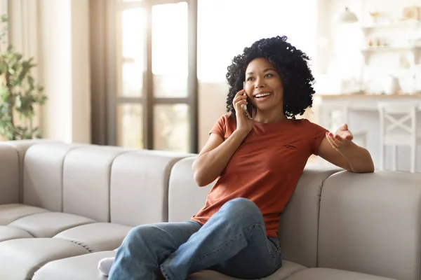 Vrolijke Zwarte Vrouw Praten Mobiele Telefoon Ontspannen Bank Thuis Glimlachende — Stockfoto