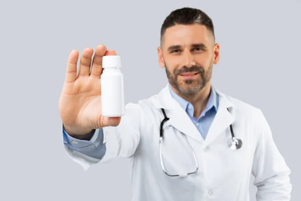 Bonito Médico Meia Idade Casaco Branco Mostrando Frasco Medicamentos Isolados — Fotografia de Stock